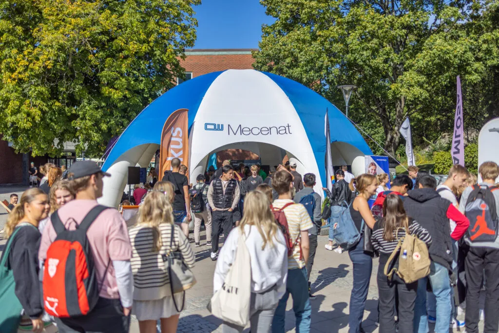 Studenter vid Mecenats tält under Mecenat Touchdown på campus